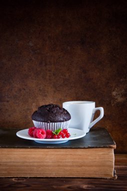 Kırmızı çilek ve siyah kahve ve eski kitaplar fincan ile Çikolatalı muffin 