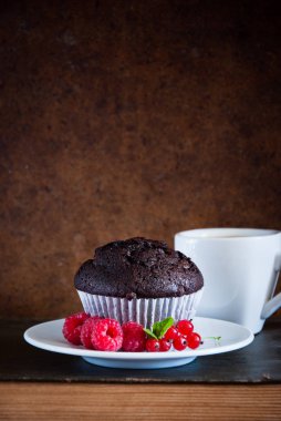 Kırmızı çilek ve siyah kahve ve eski kitaplar fincan ile Çikolatalı muffin 