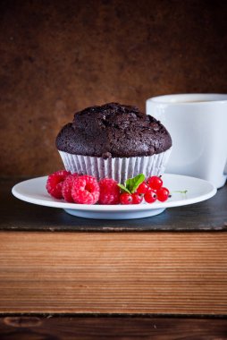 Kırmızı çilek ve siyah kahve ve eski kitaplar fincan ile Çikolatalı muffin 