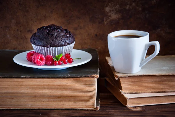 Kırmızı çilek ve siyah kahve ve eski kitaplar fincan ile Çikolatalı muffin — Stok fotoğraf