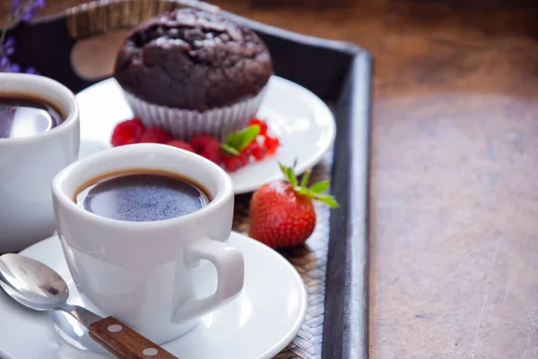 Черный кофе в белых чашках и шоколадный кекс на завтрак — стоковое фото