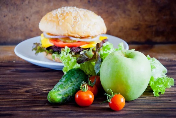 Wybór między warzywami świeżych owoców i Burger — Zdjęcie stockowe