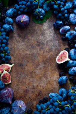 Ahşap zemin üzerinde taze incir, üzüm, erik ve çiğ