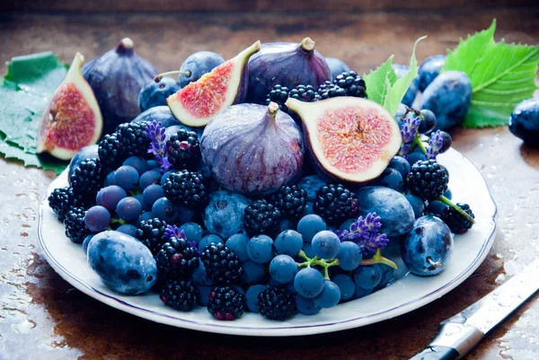 Frische Feigen, Trauben, Pflaumen und Himbeeren auf dem Teller — Stockfoto