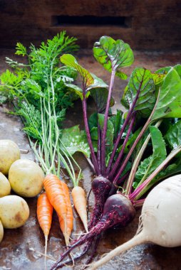 Kahverengi ahşap arka plan üzerinde Homegrown organik kök sebzeler