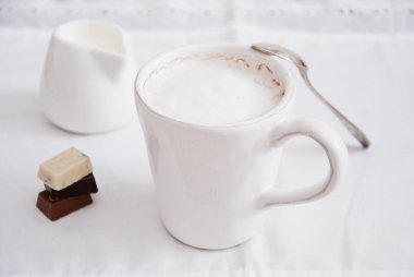 Beyaz bardakta sütlü ev yapımı kahve.