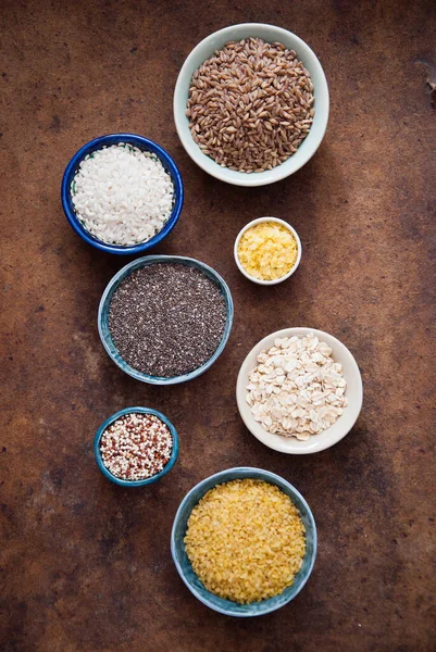 Vários cereais orgânicos e grãos em tigelas diferentes — Fotografia de Stock