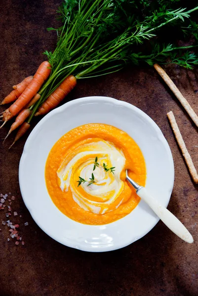 Creamy Carrot Soup on brown wooden background — Stock Photo, Image