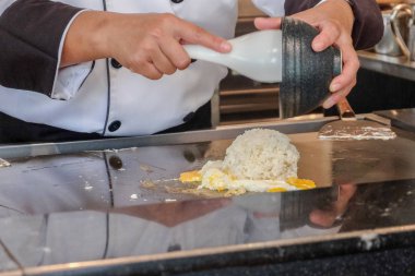 Bir adam mutfağın derinliklerinde yemek pişirir. 