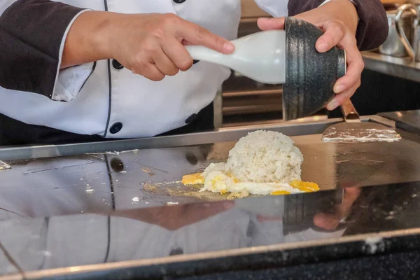 Bir adam mutfağın derinliklerinde yemek pişirir. 