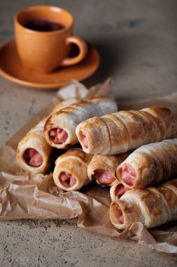 Arka planda çay ile hamur içinde sosis