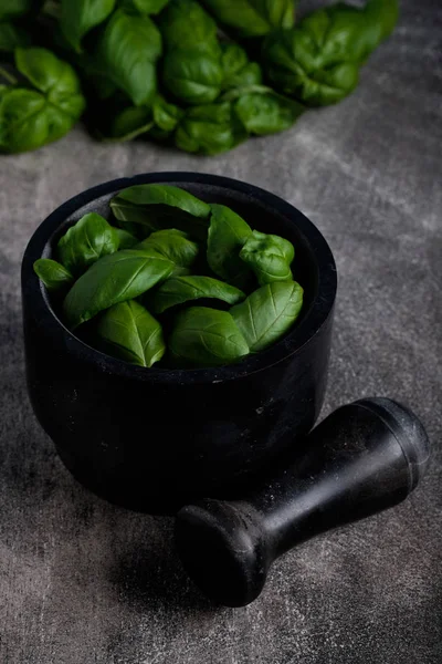 Pesto sos için siyah mermer harç fesleğen yaprakları