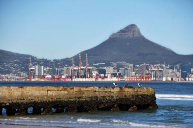 Landscape with the Cape Town container harbor and the lions head across the sea