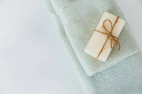 Sólido sabão com fio em toalhas de banho em fundo branco com espaço de cópia. Vista superior com espaço de cópia — Fotografia de Stock