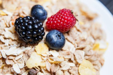 Sağlıklı kahvaltı. Mısır gevreğinde ahududu, yaban mersini, böğürtlen