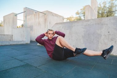 Adam dışarıda abdominaller için egzersiz yapıyor. Spor salonunda tek başına çalışacaksın.