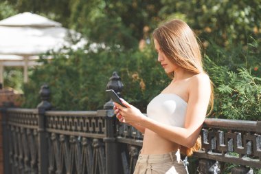 Şehir sokaklarında akıllı telefonları olan şık, güzel bir kadın.