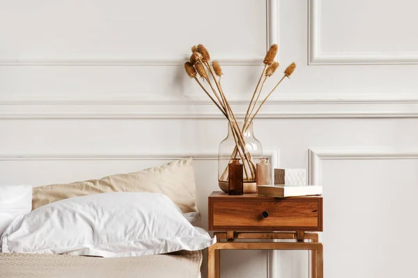 Beyaz duvarlarda alçıtaşı sıva olan beyaz yatak odasındaki samimi detaylar