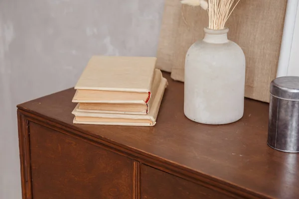 Ev ofisinin içinde kitap ve vazo bulunan retrosyon dolabı masanın üstünde. Gerçek fotoğraf. — Stok fotoğraf
