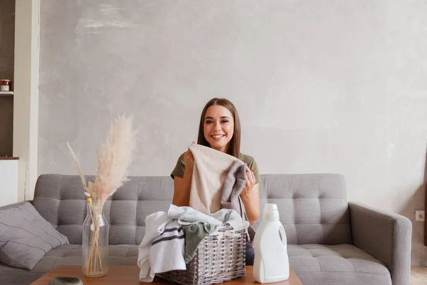 Chica disfruta de toallas limpias y olorosas después de lavar con nuevo gel detergente — Foto de Stock