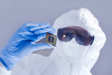 Bilgisayar bilimcisinin eldivenli elinde yeni bir yarı iletken mikroçip var. Modern teknoloji ve donanım geliştirme
