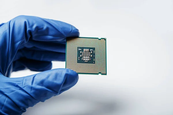 Vista de perto sobre um novo microchip semicondutor na mão enluvada do cientista da computação. Desenvolvimento moderno de tecnologia e hardware — Fotografia de Stock