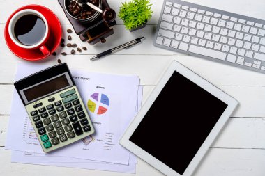 Klavye, kalem, hesap makinesi, tablet, mali veri veya grafik veya tablo ve bir fincan kahveli Modern White ofis masası. Kopya alanı olan üst görünüm. Çalışma masası konsepti.