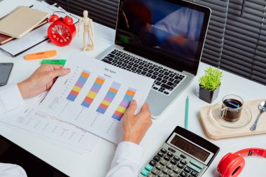 İş adamı, ofis masasında dizüstü bilgisayarla yatırım tablolarını analiz ediyor. Kapat. Mali Raporlar İstatistiksel Muhasebe Konsepti.