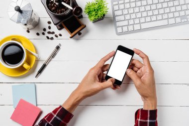 Adam elleri boş ekranı tutuyor. Çalışma alanı üzerinde bir akıllı telefon. Ürün ekranı için creen.