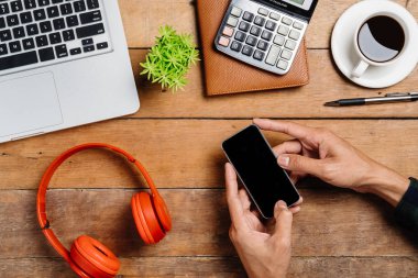 Adam elleri boş ekranı tutuyor. Çalışma alanı üzerinde bir akıllı telefon. Ürün ekranı için creen.