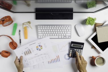 Yatırım tablolarını ofis masasında hesap makinesiyle analiz eden bir işadamı. Mali Raporlar İstatistik Muhasebe Konsepti.