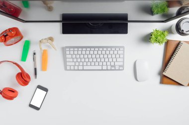 Bilgisayar, akıllı telefon, defter ve bir fincan kahve ile modern beyaz ofis masası. Kopya alanı olan üst görünüm. Çalışma masası konsepti..