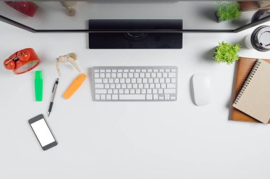Bilgisayar, akıllı telefon, defter ve bir fincan kahve ile modern beyaz ofis masası. Kopya alanı olan üst görünüm. Çalışma masası konsepti..