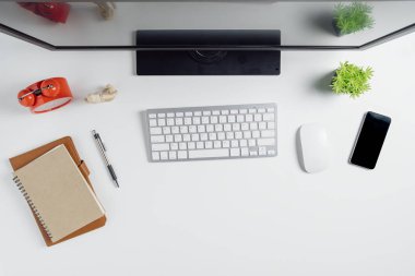 Bilgisayar, akıllı telefon, defter ve bir fincan kahve ile modern beyaz ofis masası. Kopya alanı olan üst görünüm. Çalışma masası konsepti..