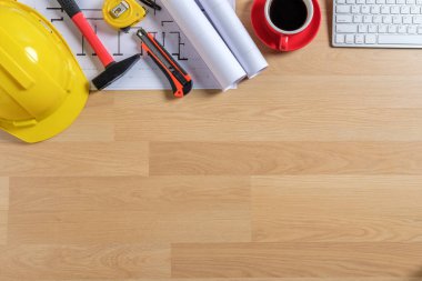 Bilgisayarlı ofis masası, bir fincan kahve ve mühendis teçhizatı. Fotokopi alanı olan üst görünüm. Arkaplan inşa projesi fikri.