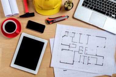 Laptop, akıllı telefon, tablet, kahve ve mühendislik donanımlı mimari ofis masası. Üst görünüm inşa projesi fikri.