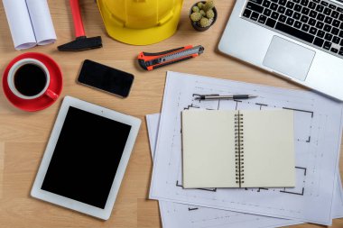 Laptop, akıllı telefon, tablet, kahve ve mühendislik donanımlı mimari ofis masası. Üst görünüm inşa projesi fikri.