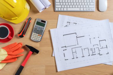 Bilgisayarlı ofis masası, bir fincan kahve ve mühendis teçhizatı. Fotokopi alanı olan üst görünüm. Arkaplan inşa projesi fikri.