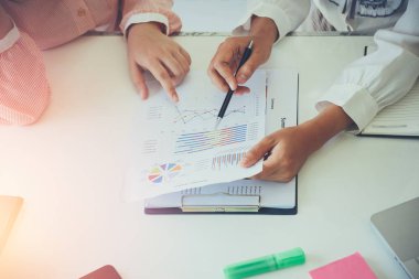 Ortak çalışma ekibi toplantısı konsepti, iş kadını gelir analizi için modern ofiste finansal veri ve dizüstü bilgisayar kullanıyor.