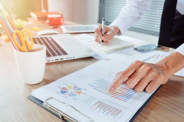 İşadamı, maliyet, hesap makinesi ve modern ofisteki cep telefonlu dizüstü bilgisayarlar hakkında finansman ile çalışıyor..