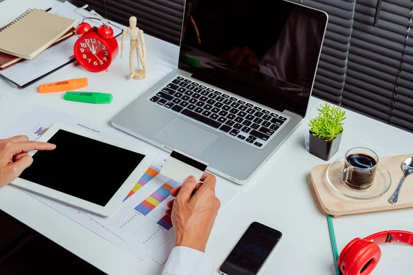 İşadamı tableti tutuyor ve online alışveriş için kredi kartı kullanıyor. İnternetten alışveriş kavramı..