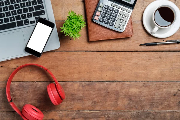 Bilgisayarlı masa masası, akıllı telefon, bir fincan kahve, kalem, kulaklık, hesap makinesi ve not defteri. Fotokopi alanı olan üst görünüm. Ofis malzemeleri ve cihazlar masa üstünde. Çalışma masası konsepti..