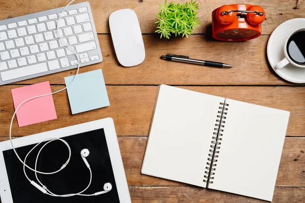 Klavye, fare, not defteri, kulaklık, kalem, tablet, saat ve kahve ile ofis malzemeleri. Kopya alanlı üst görünüm. Çalışma masası konsepti..