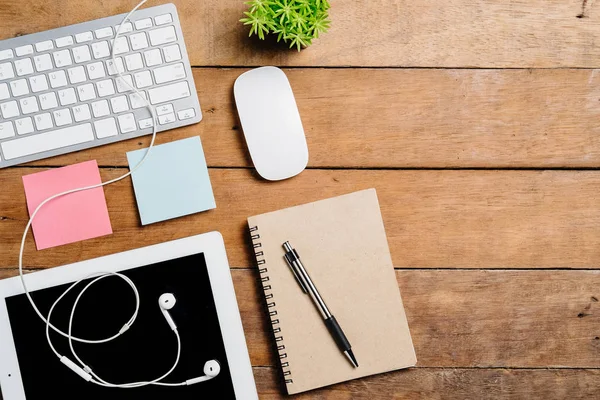 Klavye, fare, not defteri, kulaklık, kalem, tablet, saat ve kahve ile ofis malzemeleri. Kopya alanlı üst görünüm. Çalışma masası konsepti..