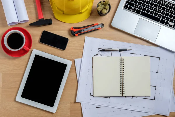 Laptop, akıllı telefon, tablet, kahve ve mühendislik donanımlı mimari ofis masası. Üst görünüm inşa projesi fikri.