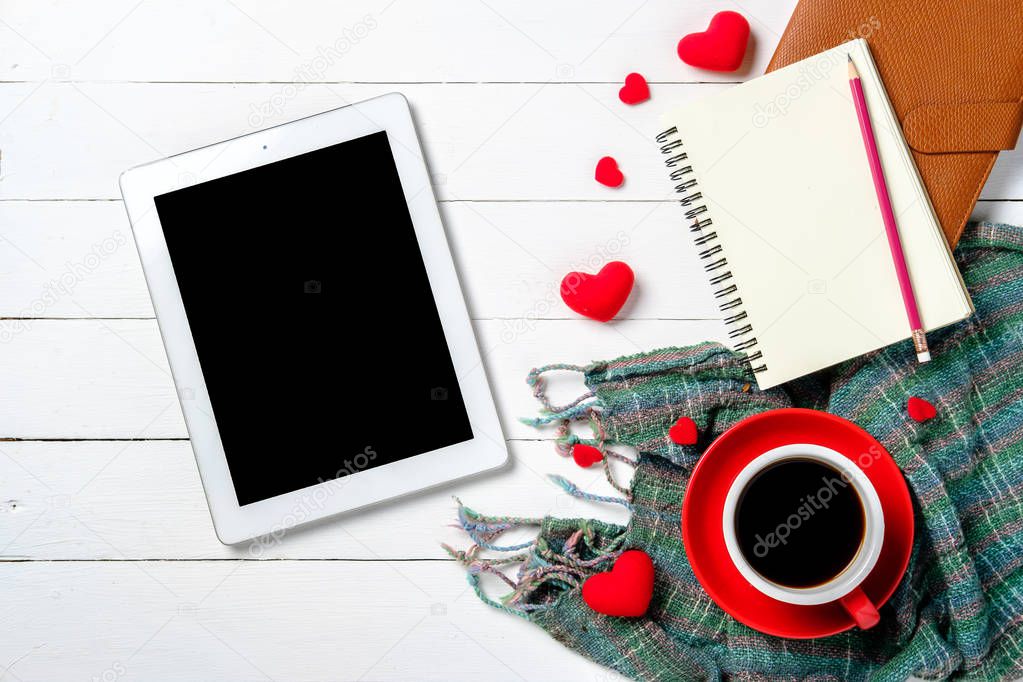 Wooden white background with red hearts, notebook,pencil,tablet and red cup of coffee with copy space. The concept of Valentine Day,Wedding day.