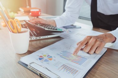 İş adamı, maliyet, hesap makinesi ve dizüstü bilgisayarla ilgili finansman ile modern ofisin masasında çalışıyor. Yakın plan. İş analizi ve strateji kavramı..