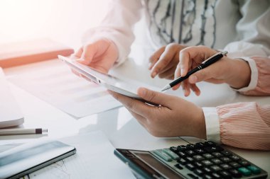 Modern tablet bilgisayarla gelir tablolarını ve grafiklerini analiz eden bir iş ekibi. Kapat. İş analizi ve strateji kavramı.