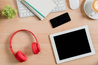 Renkli kalemlerle, renkli suyla, defterle, kalemle, tabletle, akıllı telefonla ve bir fincan kahveyle dolu ofis masası. Ürün gösterimi için kullanılacak..