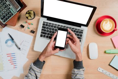 Adam elleri boş ekranı tutuyor. Çalışma masasında bir akıllı telefon. Ürün gösterimi için boş ekran..